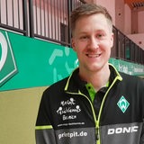 Werders Tischtennis-Profi Mattias Falck lächelt bei einem Interview in der Sporthalle.