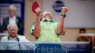 Werders Tischtennis-Profi Kirill Gerassimenko reckt im Jubelschrei die Fäuste hoch und legt den Kopf dabei in den Nacken.