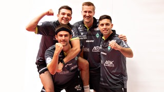 Die vier Tischtennisspieler von Werder Bremen Mattias Falck, Kirill Gerassimenko, Marcelo Aguirre und Cristian Pletea posieren lachend und kämpferisch.