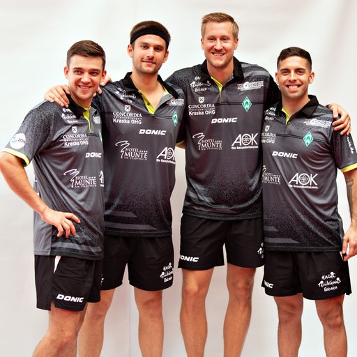 Die vier Tischtennisspieler von Werder Bremen Mattias Falck, Kirill Gerassimenko, Marcelo Aguirre und Cristian Pletea posieren lächelnd Arm in Arm für ein Teamfoto.