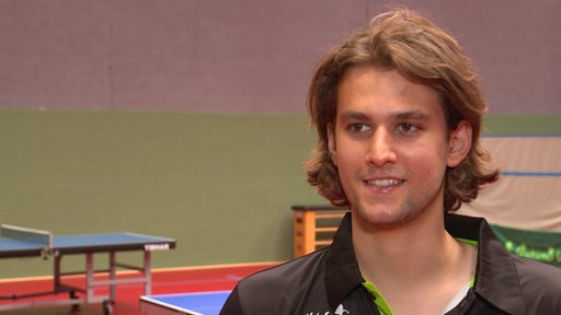 Werders Tischtennis-Neuzugang Cristian Pletea lächelt während eines Interviews in der Trainingshalle.