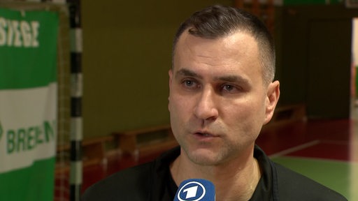 Tischtennis-Trainer Cristian Tamas von Werder Bremen steht in der Bremer Sporthalle nach dem Spiel beim Interview.