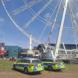 Polizeiautos stehen vor einem Riesenrad.