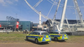 Polizeiautos stehen vor einem Riesenrad.