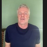Tom Bartels steht vor einer grünen Wand.