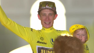 Der Däne Jonas Vingegaard (Gewinner der Tour de France) mit seinem Sohn auf dem Arm bei der Presiverleihung.