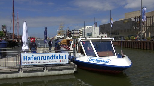Ein Bootsanleger im Hafen von Bremerhaven mit Touristen, die eine Hafenrundfahrt machen wollen.