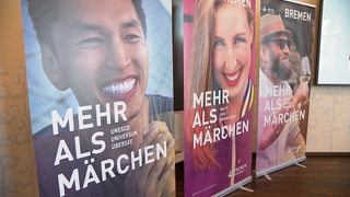 Mehrere Werbeplakate stehen in einem Raum bei einer Pressekonferenz