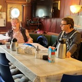 Männer in einer Kajüte und trinken Kaffee