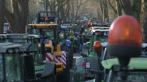 Viele Traktoren blockieren eine Straße.