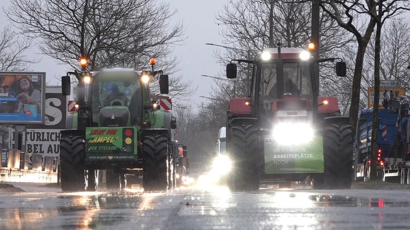 Trecker fahren mit Schildern auf einer Straße.