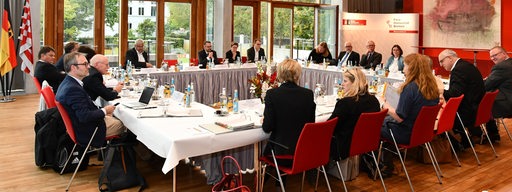 Vertreter des Bremer Senates und der Bundesregierung sitzen um einen großen Tisch