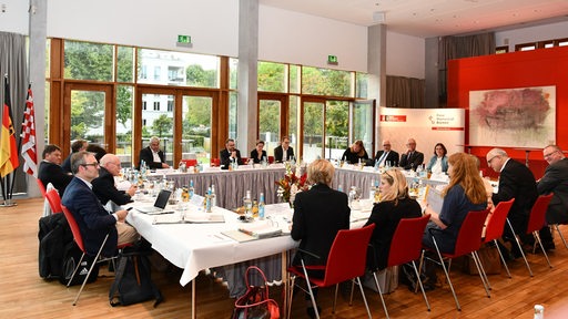 Vertreter des Bremer Senates und der Bundesregierung sitzen um einen großen Tisch