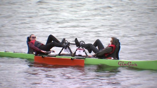 Zwei Mädchen sitzen in einem selbstgebauten Tretboot auf dem Werdersee.