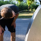 Ein Sportler trinkt Wasser an einem öffentlichen Trinkwasserspender