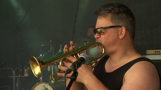 Ein Trompeter spielt auf der Bühne beim Burning Beans Festival.