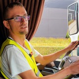 Ein junger Mann hinter dem Steuer eines LKW.
