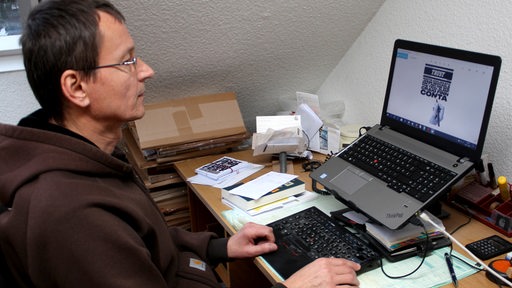 Dolf Hermannstädter vom Magazin Trust sitzt am Computer.