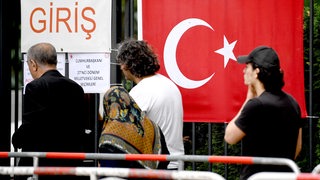 Wahlberechtigte stehen vor dem Gelände des türkischen Generalkonsulats Berlin für die Stimmabgabe