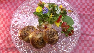 Türkische Hefeplätzchen mit Kräutern und Schafskäse zusammen mit einem bunten Salat und marinierten Tomaten.