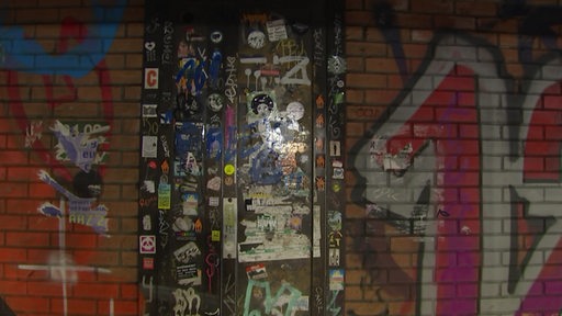 Eine geheimnisvolle Tür mit Stickern beklebt, in einem Tunnel in Findorff.