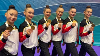 Das sechsköpfige Junioren-Team der Rhythmischen Sportgymnastik von Bremen 1860 steht strahlend nebeneinander aufgereiht und hält seine Bronzemedaille vom internationalen Turnier in Portugal hoch.