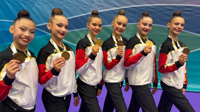 Das sechsköpfige Junioren-Team der Rhythmischen Sportgymnastik von Bremen 1860 steht strahlend nebeneinander aufgereiht und hält seine Bronzemedaille vom internationalen Turnier in Portugal hoch.