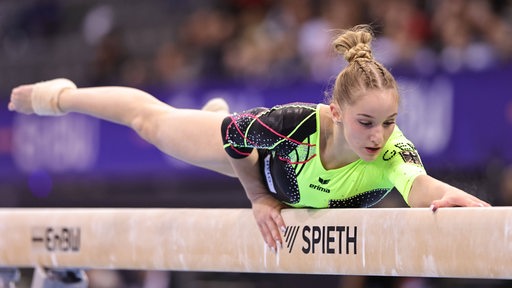 Die Bremer Turnerin Karina Schönmaier liegt bei einer Übung beim DTB-Pokal in Stuttgart ausgestreckt auf dem Schwebebalken.