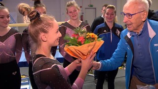 BremensTurnerin Karina Schönmaier bekommt nach ihrem Aufstieg einen Blumenstrauß überreicht.