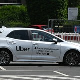 Ein Fahrzeug vom Fahrtenvermittler Uber steht auf einem Parkplatz.