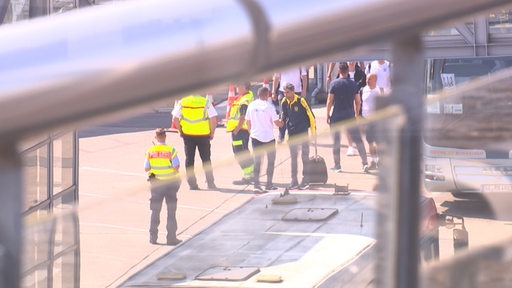Mehrere Spieler der ukrainischen Fußballnationalmannschaft stehen auf dem Rollfeld des Bremer Flughafens.