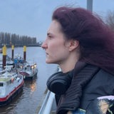 Eine junge Frau mit lila Haaren steht an der Weser
