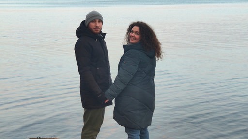 Yana Makhovska und ihr Mann Mykhailo aus der Ukraine stehen an einem Ufer