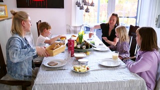 Geflüchtete aus der Ukraine sitzen mit Bremer Familie an deren Esstisch. 