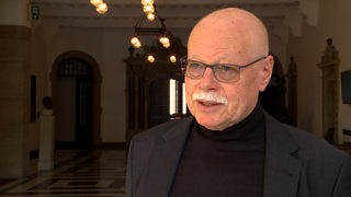 Bremens Innensenator, Ulrich Mäurer, blickt in eine Kamera
