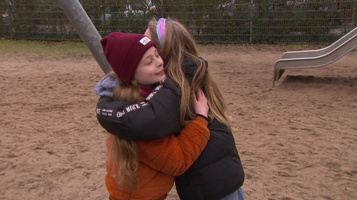 Zwei Mädchen umarmen sich 
