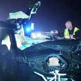Ein Polizist untersucht das Wrack eines Unfallwagens auf der A1 bei Wildeshausen.