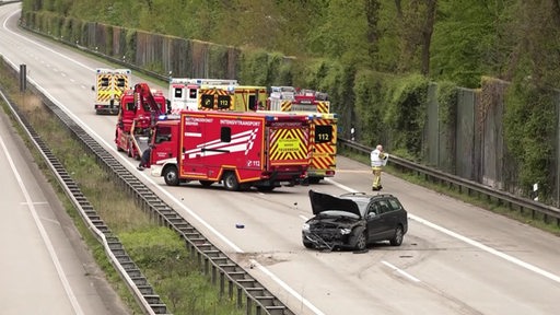 Ein Unfallauto und mehrere Rettungswagen auf der Autobahn.