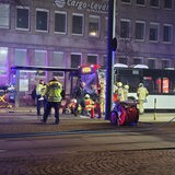 Einsatzkräfte stehen um einen Bus, der an der Front beschädigt ist.