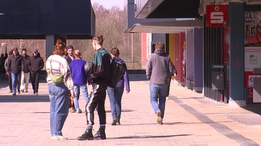 Menschen laufen auf dem Boulevard der Uni Bremen
