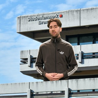 Ein junger Mann schaut in die Kamera.