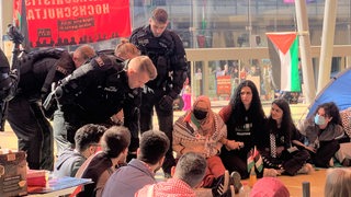 Polizisten in der Glashalle der Universität  