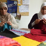Zwei Frauen stricken in einer Flüchtlingsunterkunft.