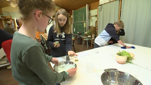 Kinder einer Waldorfschule lernen während des Gartenbau Unterrichts das Kochen