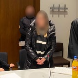 Die angeklagte Millionendiebin (verpixelt) im Gerichtssaal neben ihrem Anwalt.