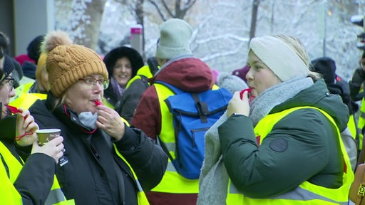 Drei Frauen mit Trillerpfeifen auf einer Ver.di-Demonstration.