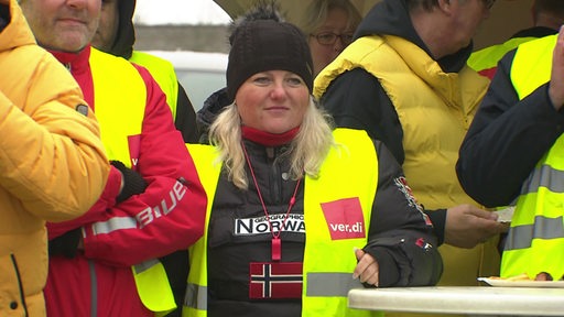 Eine Frau, die für Verdi in Bremerhaven für die Mitarbeitenden des öffentlichen Nahverkehr streikt. 