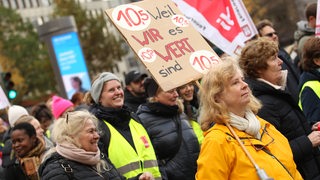 Beschäftigte streiken, halten Plakate und tragen Verdi-Westen