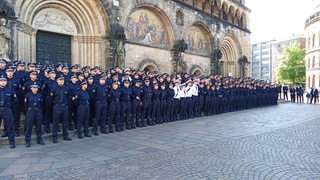 Mehr als 200 Polizeianwärter stehen vor einem Gebäude