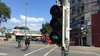 Fahrradfahrer fahren über eine Kreuzung während die Ampel grün zeigt